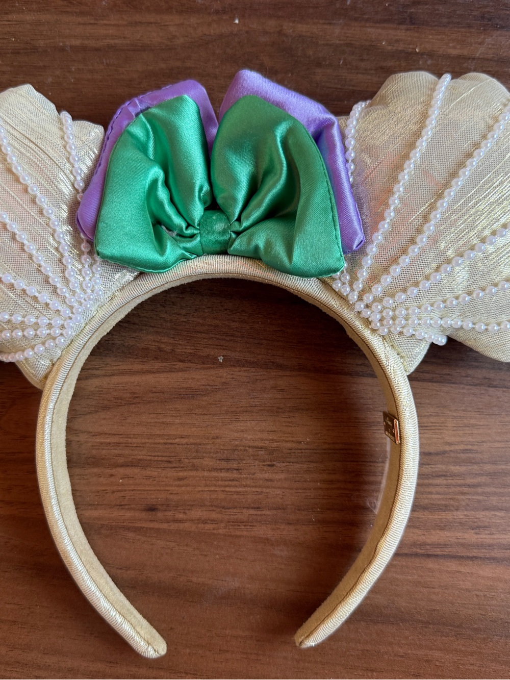 Disney Gold Pearl Shell Ear Headband with Green and Purple Bow